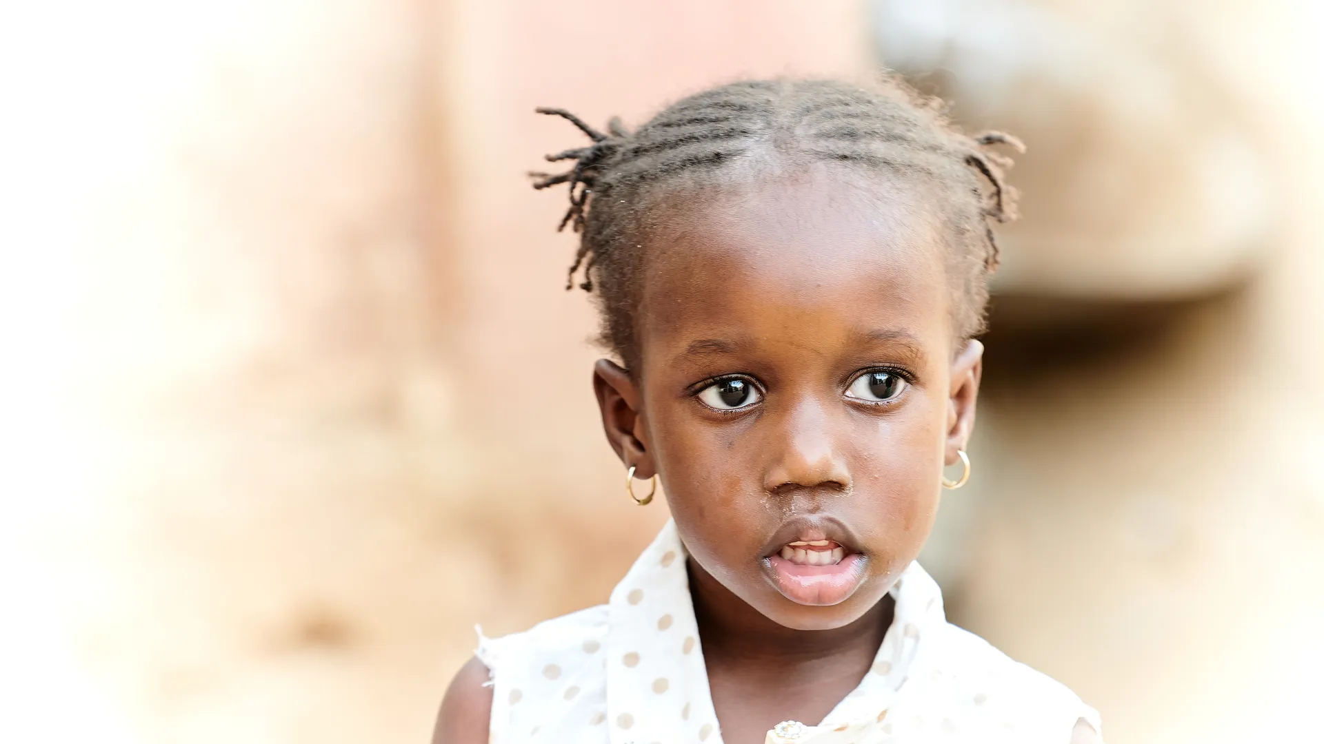 Portrait of a young African girl with braided hair and small earrings
