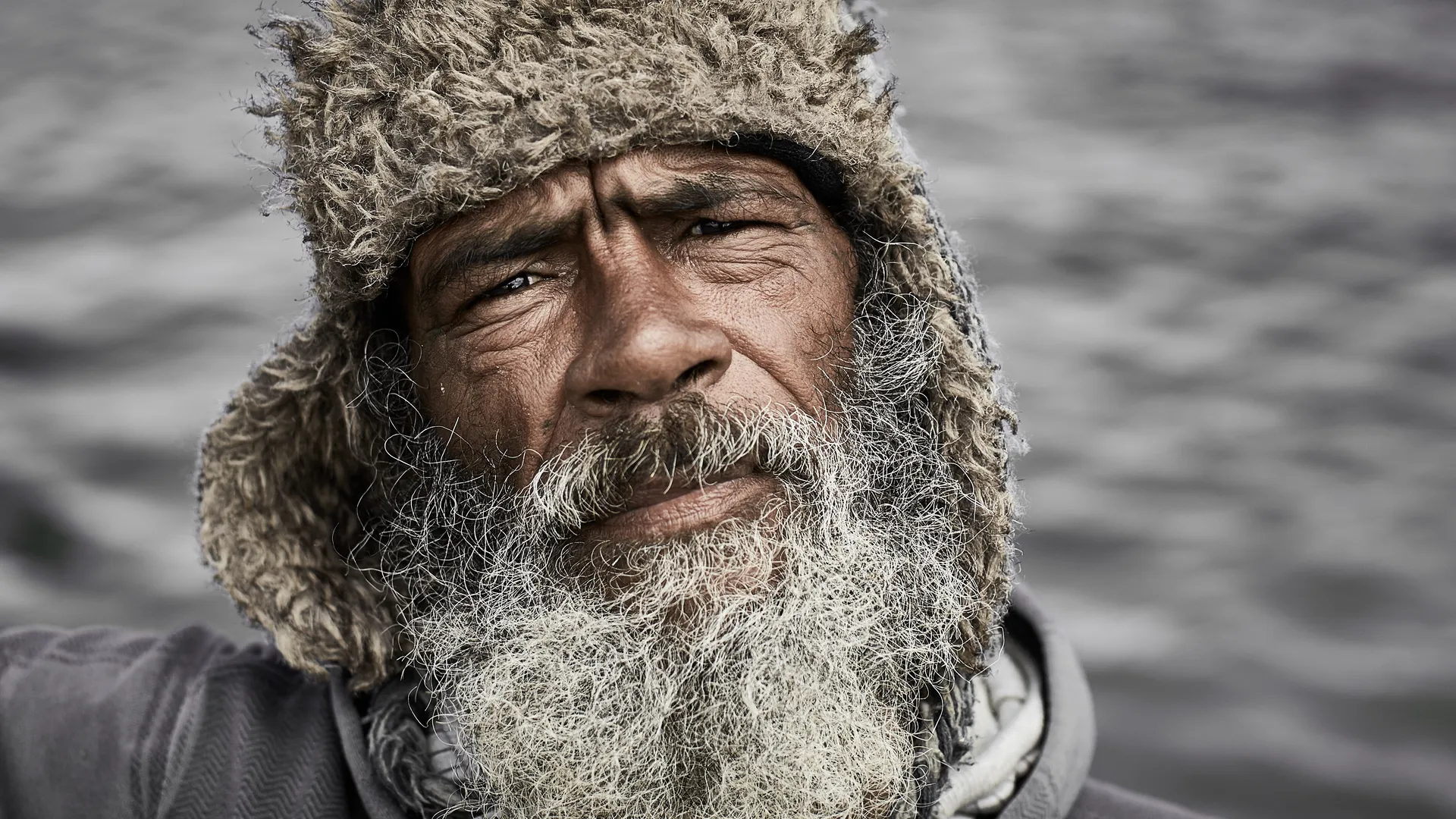 Portrait of a bearded fisherman wearing a fur hat by the sea, Hout Bay, Cape Region, South Africa